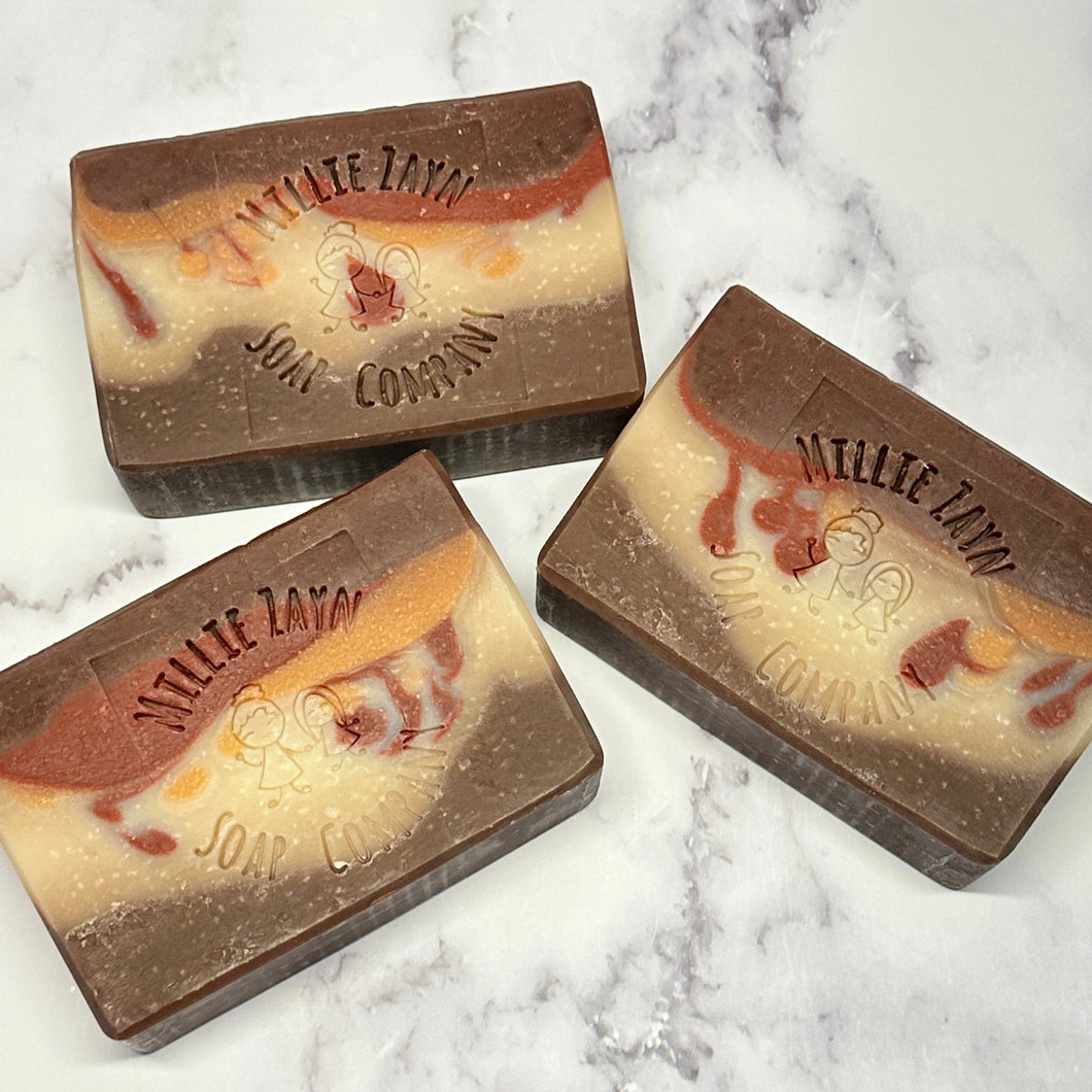 brown soap bar with a white stipe in the middle that is mixed with gold and red